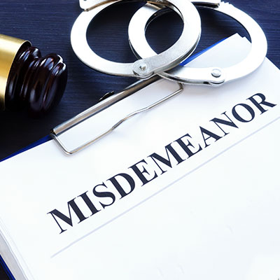Close-up of misdemeanor legal paperwork with handcuffs and gavel