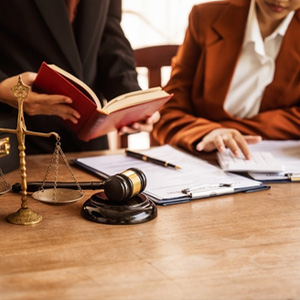 Criminal defense attorneys reviewing documents and law books for a client in Miami-Dade, FL.